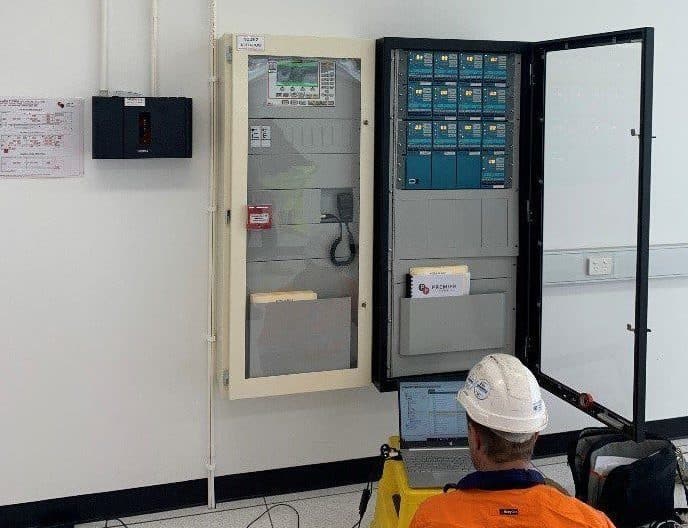 fire safety engineer checking the alarm system of a building with his laptop